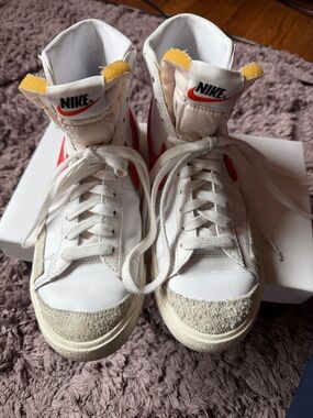 Nike White High-Top Sneakers with Red Swoosh and Yellow Tongue Tabs